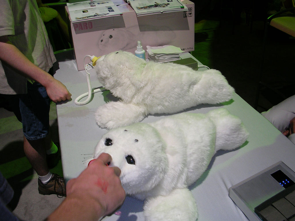 Two fluffy white seal toys sitting on a table.