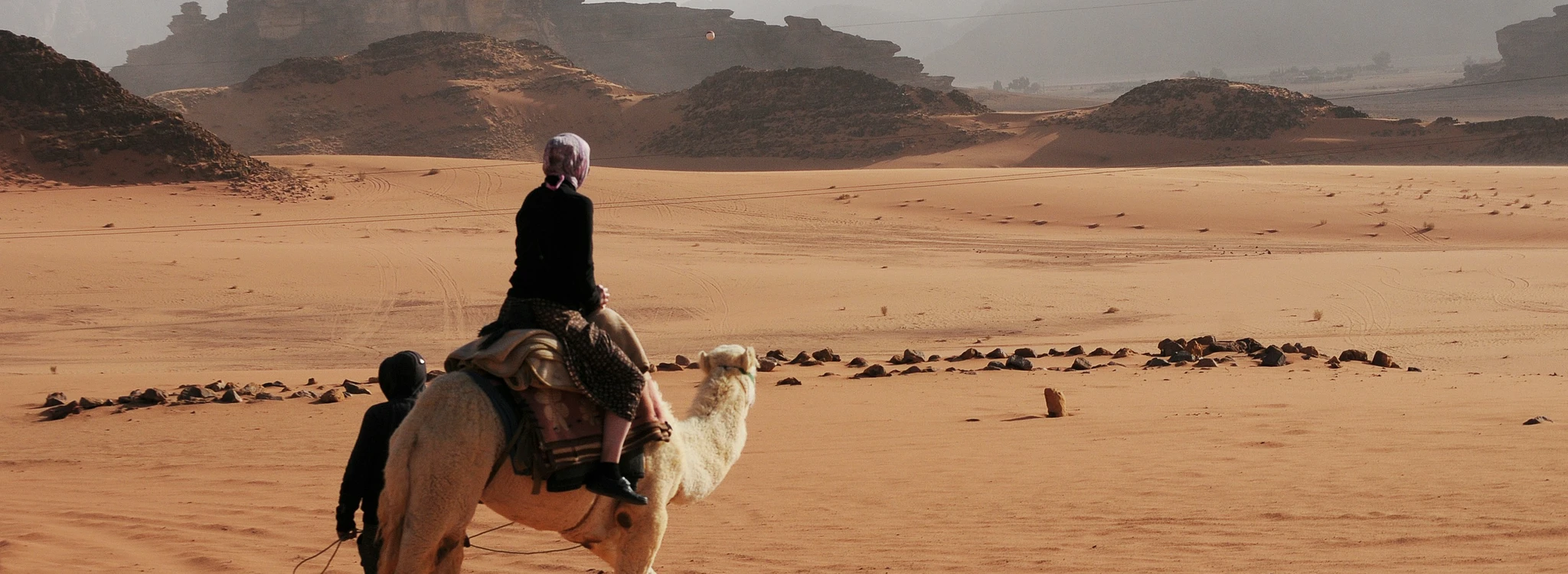 Woman riding a camel in the desert
